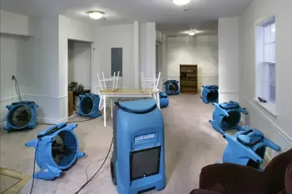 Air movers and an LGR dehumidifier drying a room after a water loss