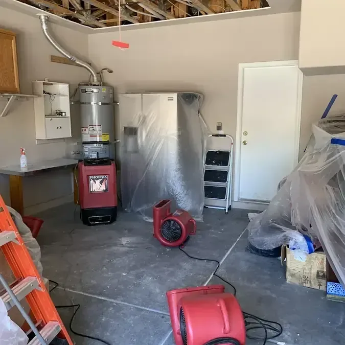 Garage with the ceiling opened and drying equipment running after a water heater leak