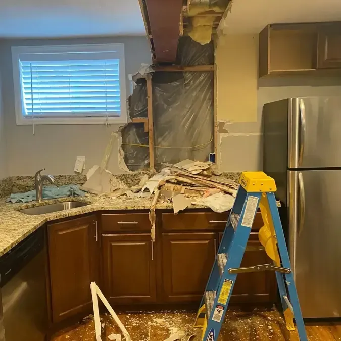 Kitchen ceiling cut open so a leak from the floor above can dry out