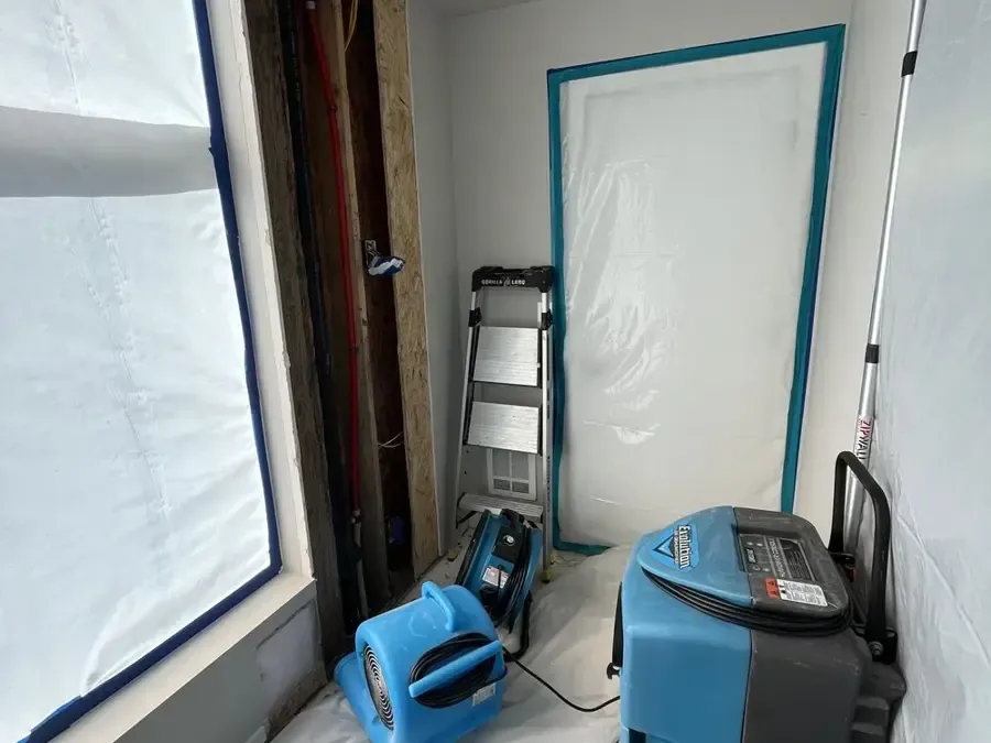 Plastic containment wall with an air mover and a dehumidifier running inside during a dry-out