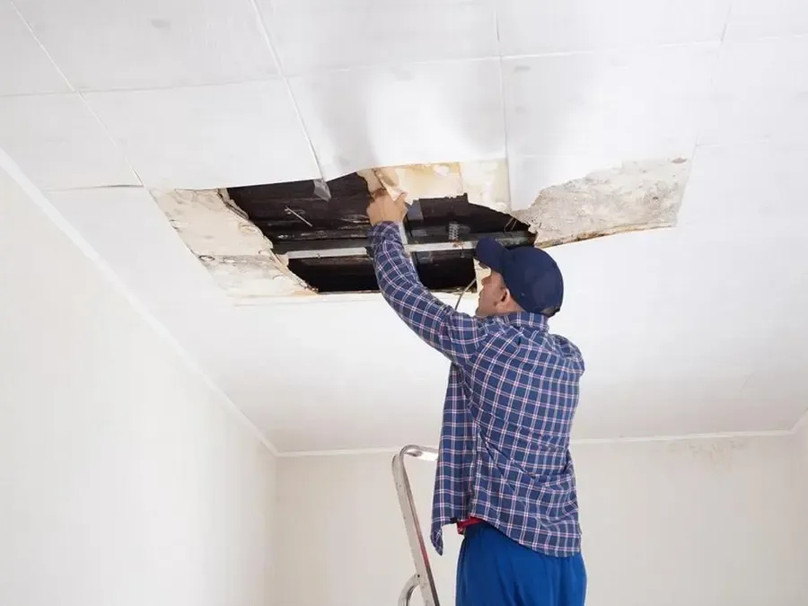 Wet ceiling drywall opened so the joists can dry after a leak from above