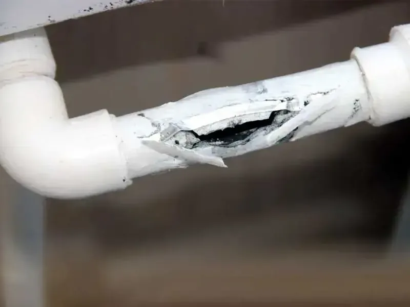 White plastic supply pipe split lengthwise after freezing